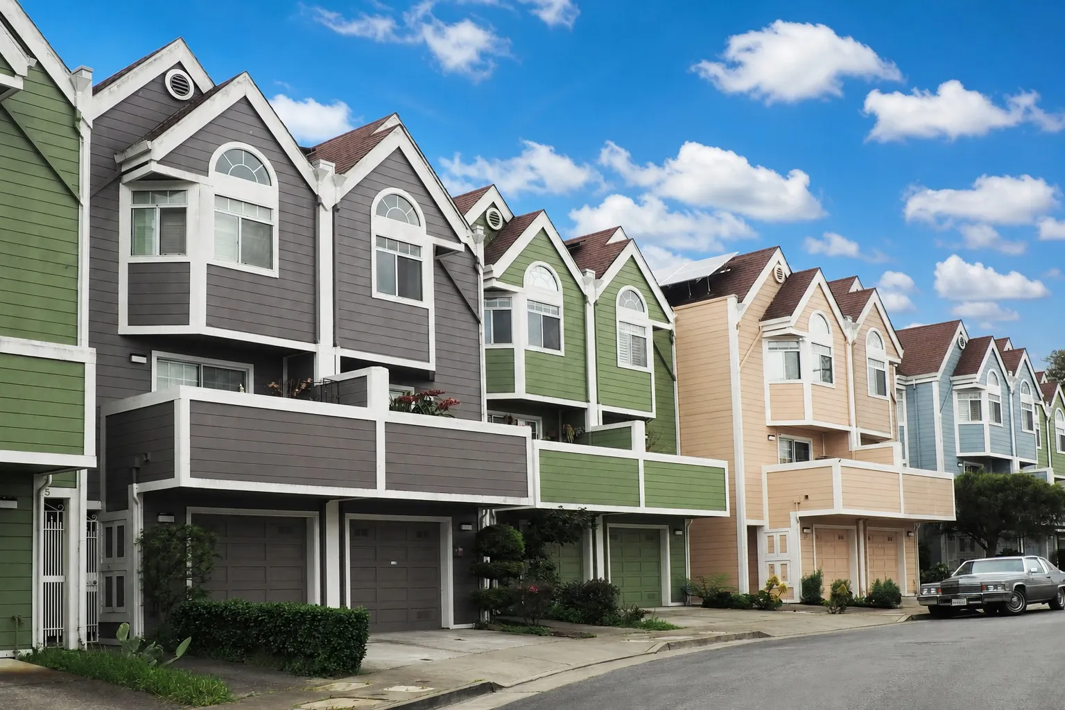 A row of colorful Colorado townhouses under a bright blue sky